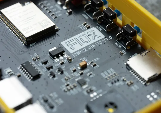 Close-up photo of a PCB made with Flux, with an ESP32 module, buttons, and a microSD slot.