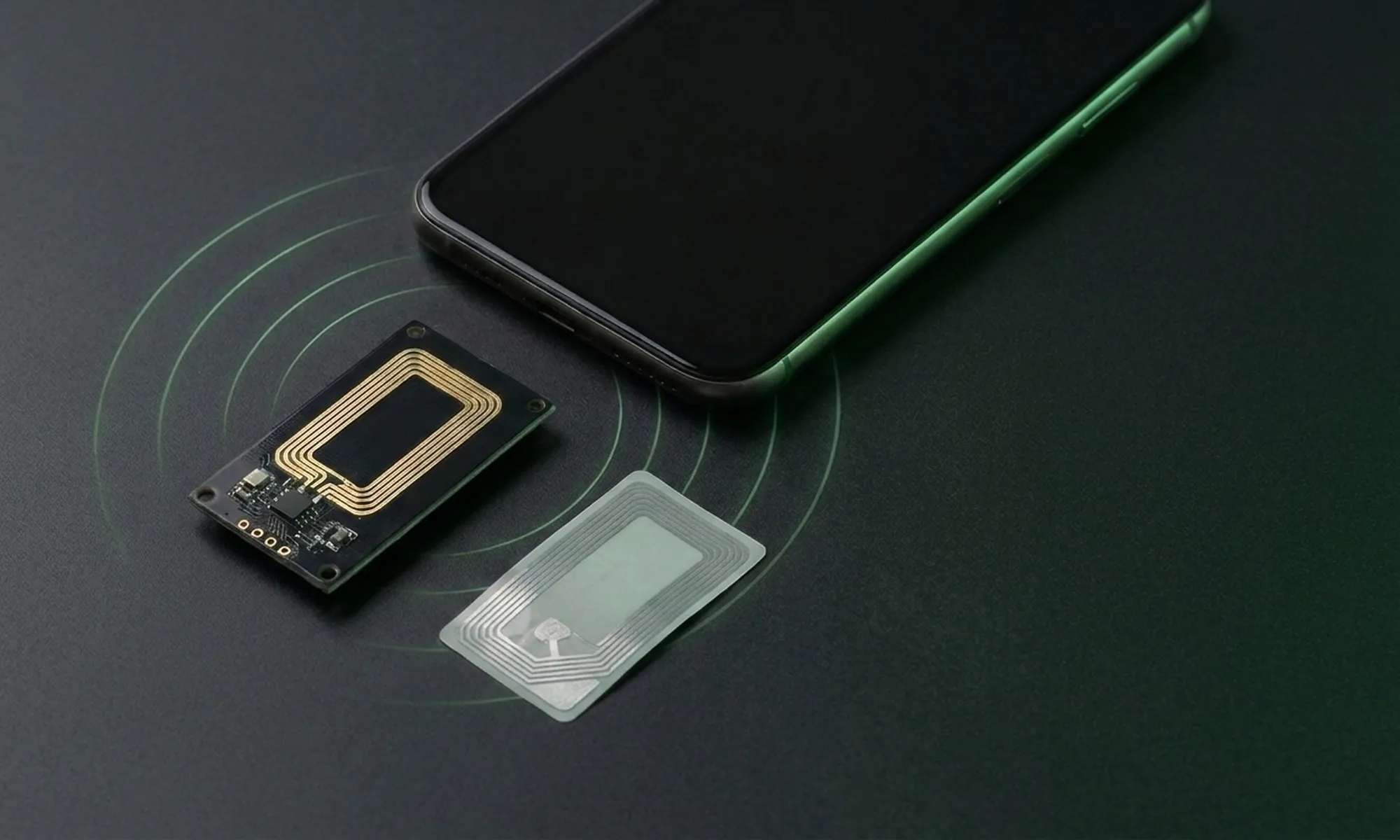 A smartphone beside an NFC reader board and a contactless tag.